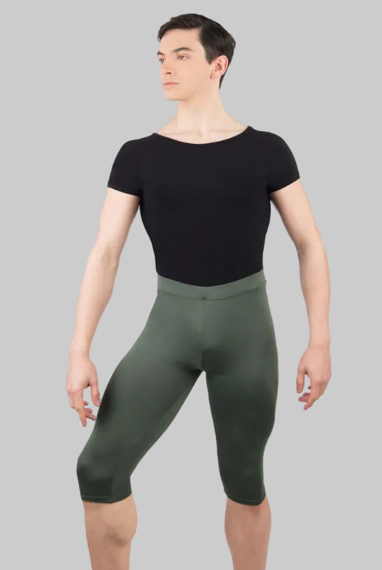 A male model wearing a black scoop neck dance shirt with short sleeves and an attached dance belt.